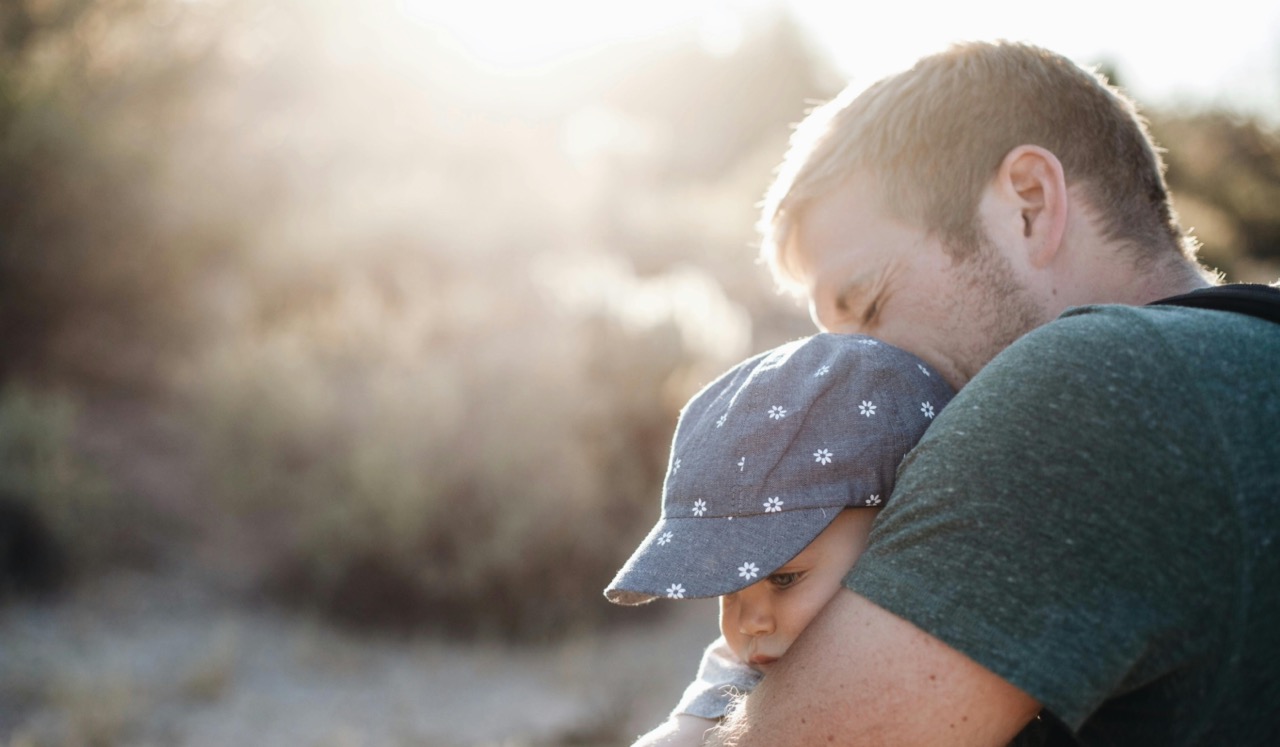 father-daughter Man holding his daughter with sun shining in the background